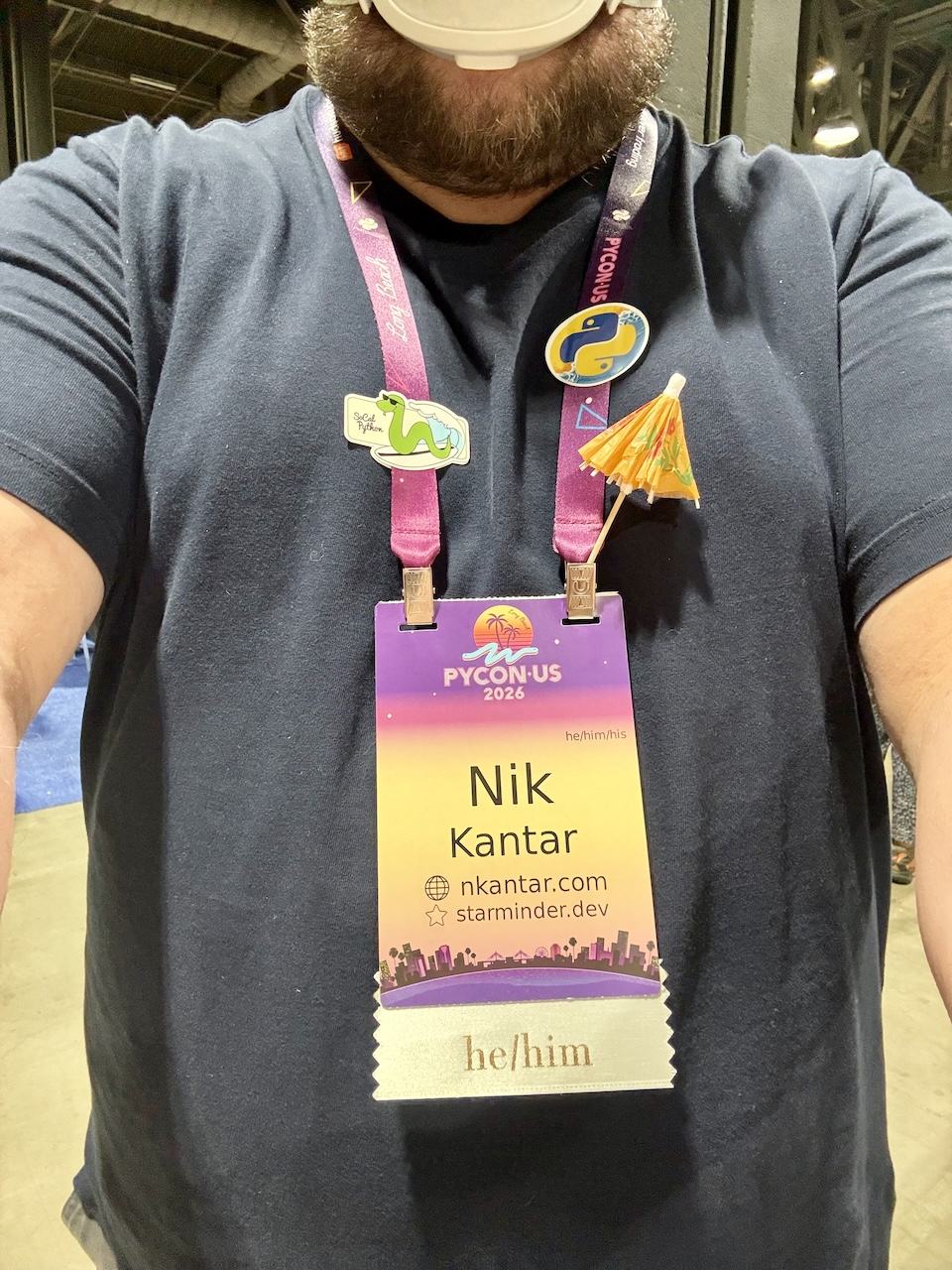 conference badge with “Nik Kantar”, “nkantar.com”, “starminder.dev”, and “he/him”