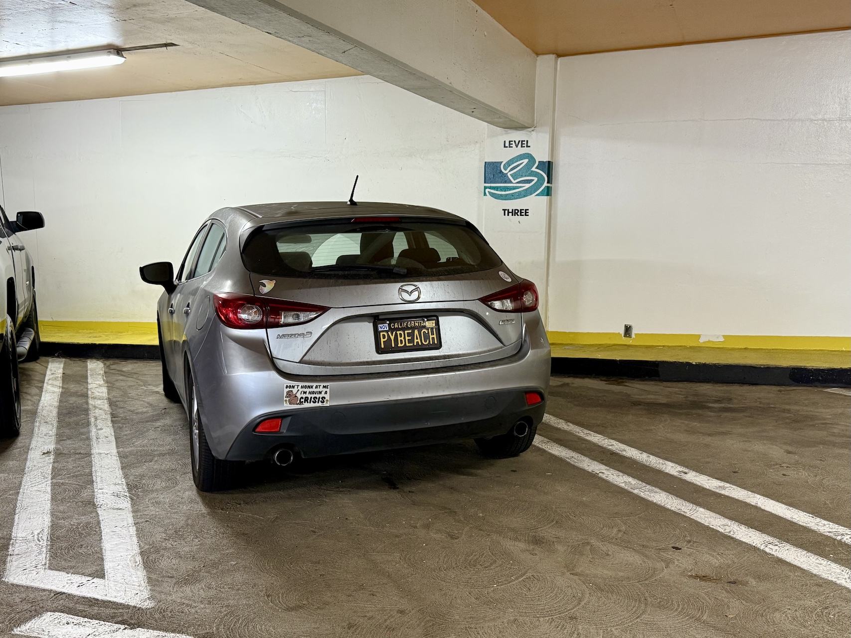 my silver 2014 Mazda3 hatchback with the PYBEACH license plate parked next to the PyBeach 2025 venue